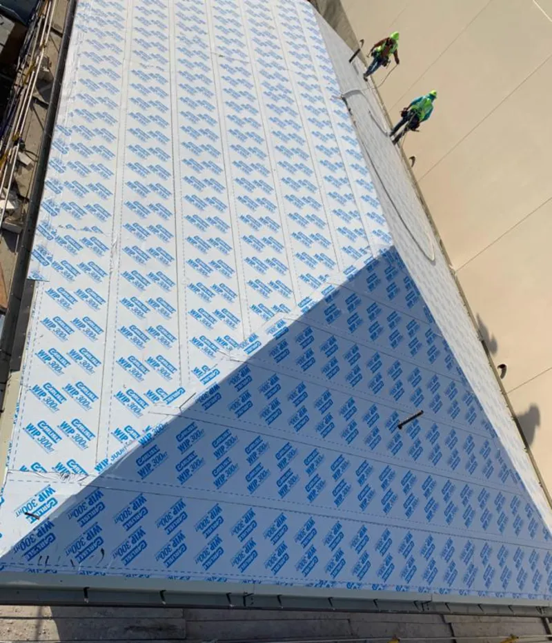 Professional roofers installing underlayment on a metal roof in San Mateo